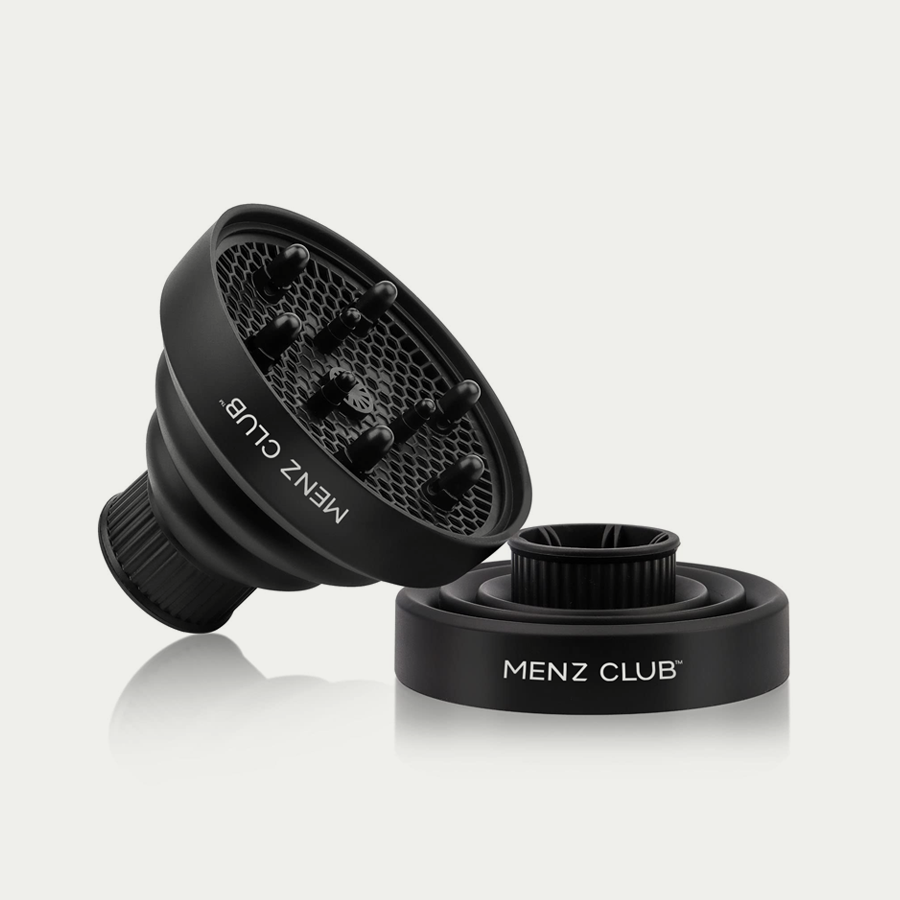 Black bottle of sea salt hair foam on sand.