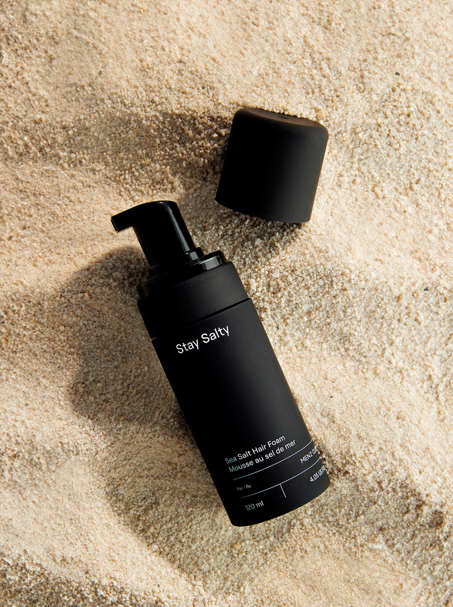 Profile of a man with curly hair, a beard, and a patterned shirt.