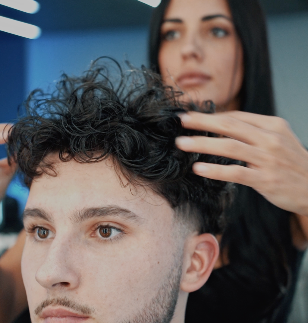 Man in a denim jacket resting his head on his hand, looking at the camera.