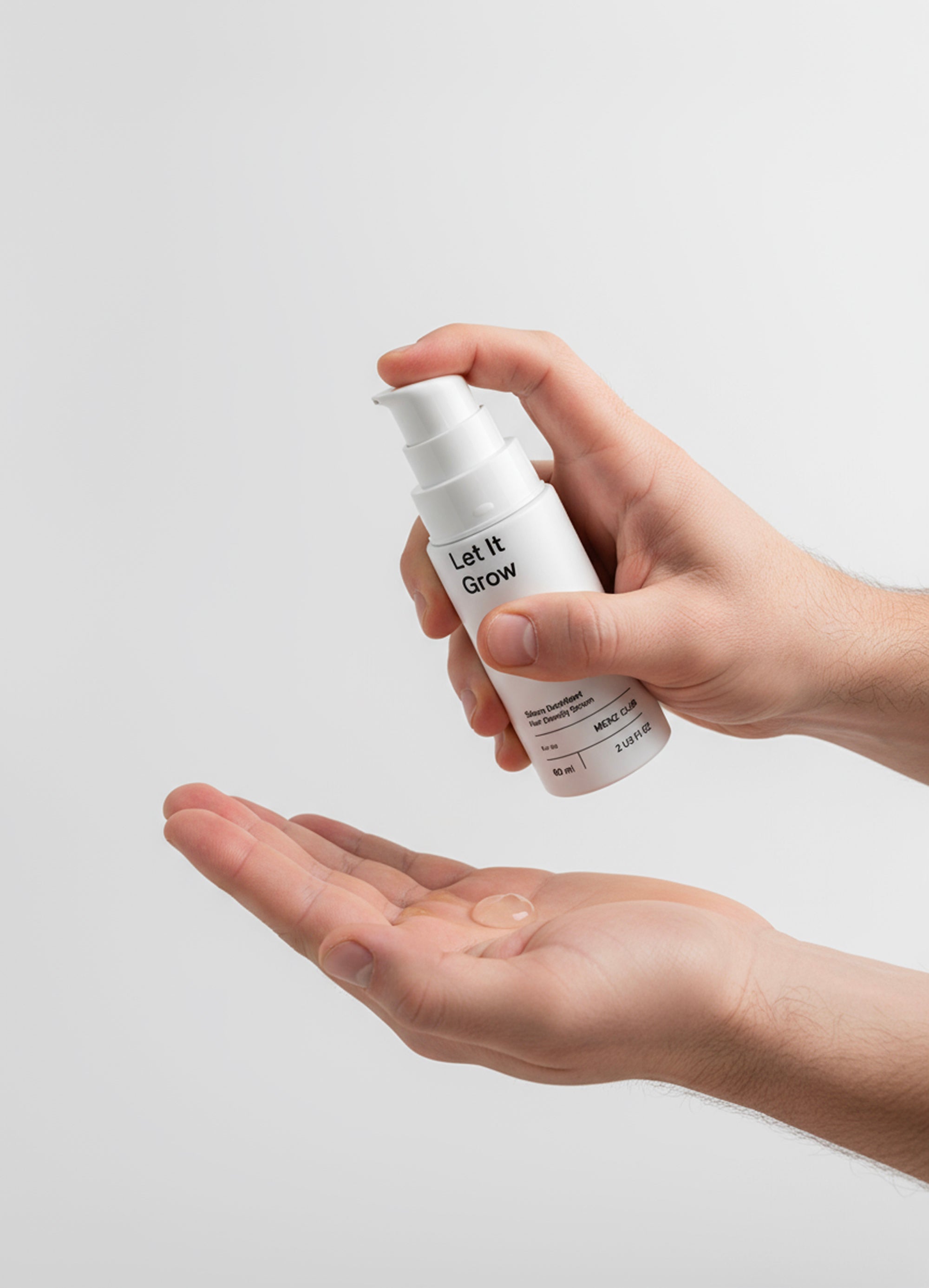 Black bottle of sea salt hair foam on sand.